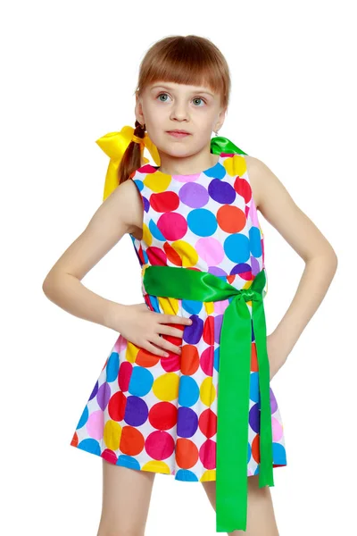 Una niña en un vestido con un patrón de circl multicolor —  Fotos de Stock