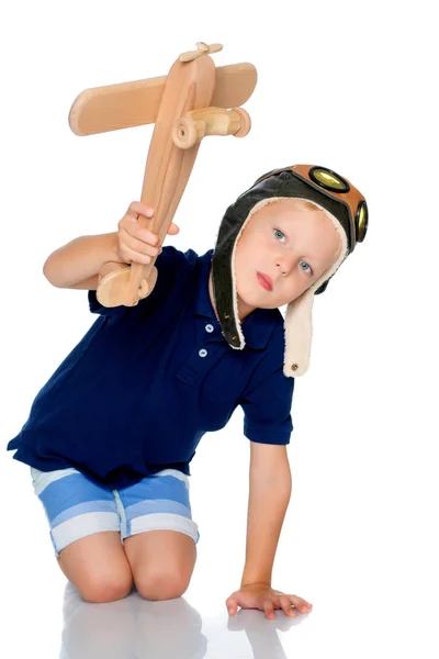 Liten pojke med ett trä plan. — Stockfoto