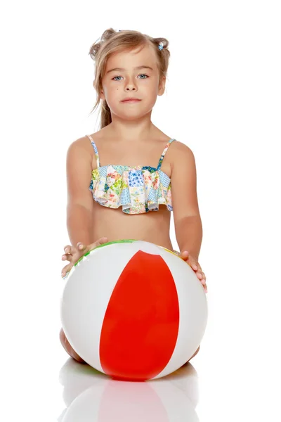 Маленькая девочка в купальнике с мячом — стоковое фото