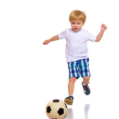 Küçük çocuk bir futbol topuyla oynuyor.
