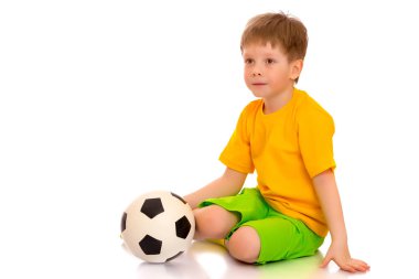 Küçük çocuk bir futbol topuyla oynuyor.