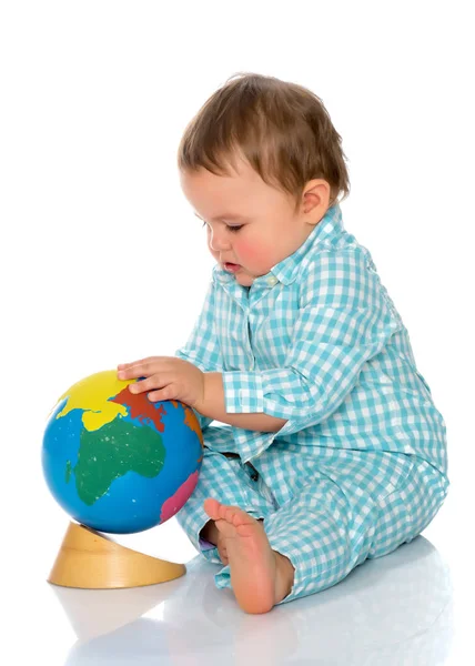 A little boy is playing with a globe. — Stock Photo, Image