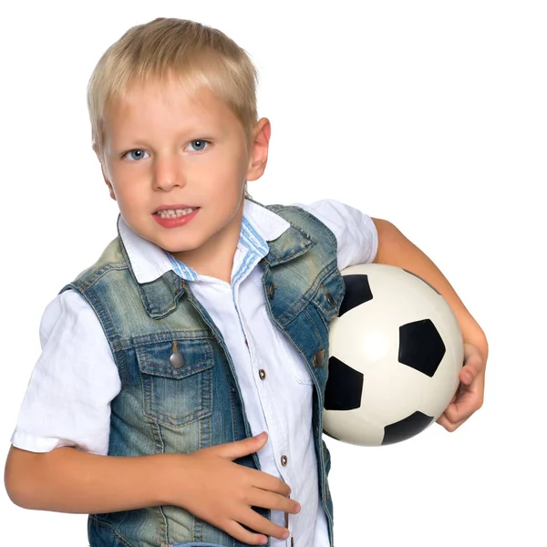 Menino está jogando com uma bola de futebol . — Fotografia de Stock