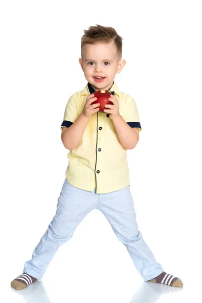 The little boy takes a bite of an apple. — Stock Photo, Image