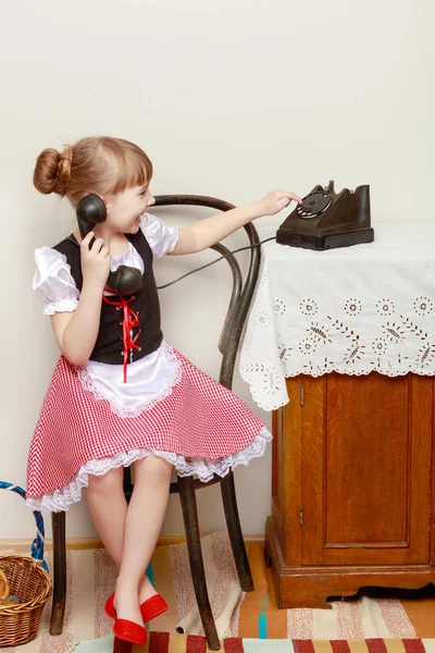 The girl is talking on the old phone. — Stock Photo, Image