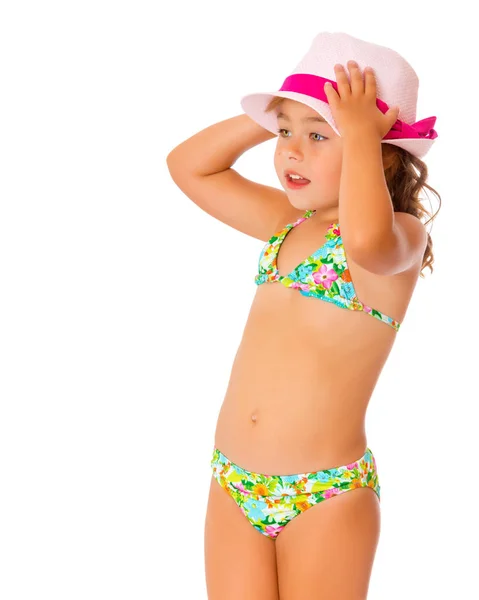 Una piccola ragazza abbronzata in costume da bagno e cappello . — Foto Stock