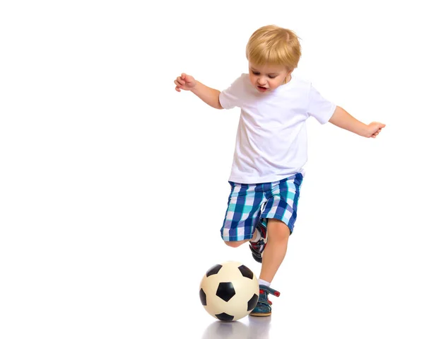 Menino está jogando com uma bola de futebol . — Fotografia de Stock