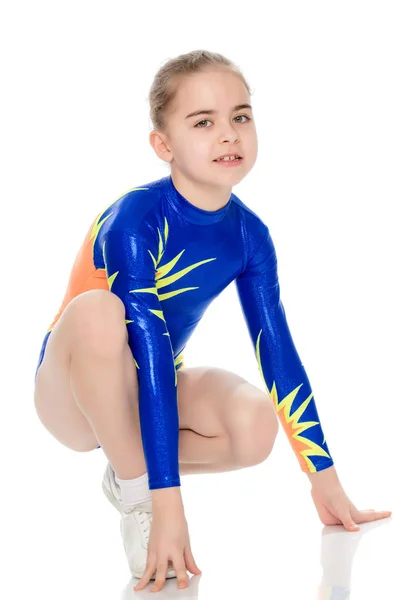 Krásná malá gymnastka dívka v podřepu. — Stock fotografie