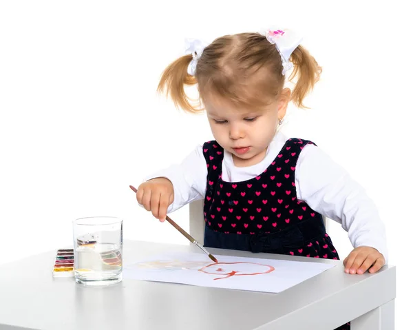 Uma menina está desenhando na mesa . — Fotografia de Stock