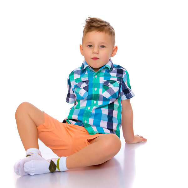 маленький мальчик сидит на полу
