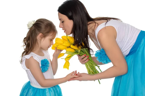 Mãe e filha cheirando tulipas amarelas . — Fotografia de Stock