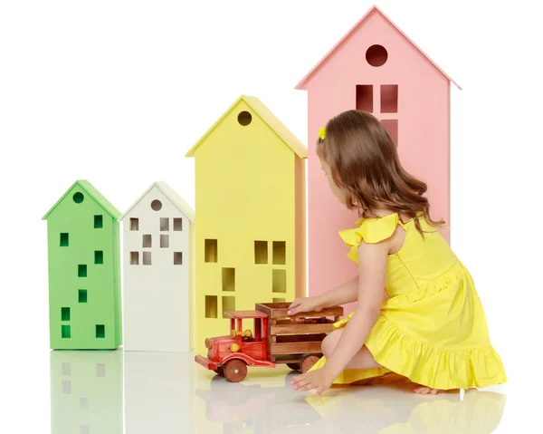 Маленькая девочка играет с деревянной машиной . — стоковое фото