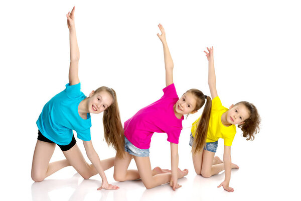 A group of girls gymnasts perform exercises.