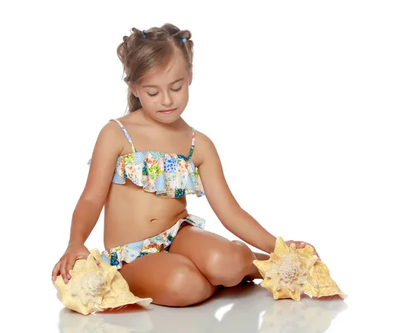 Bambina in costume da bagno con conchiglia — Foto Stock