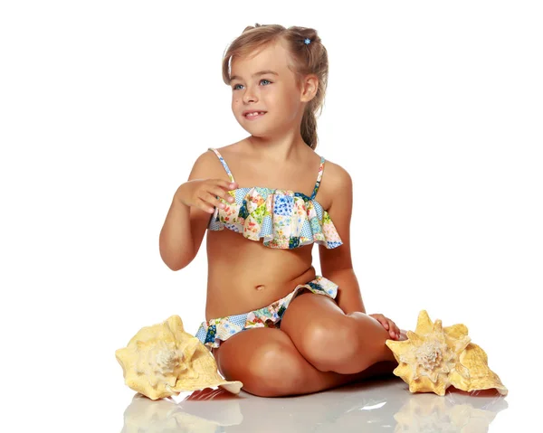 Bambina in costume da bagno con conchiglia — Foto Stock
