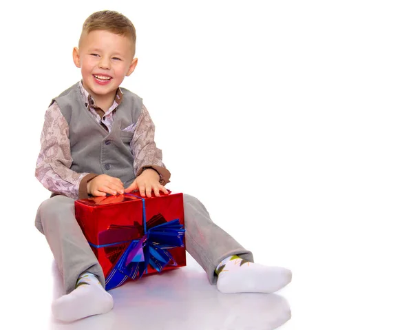 Kleine jongen met een kerstcadeau. — Stockfoto