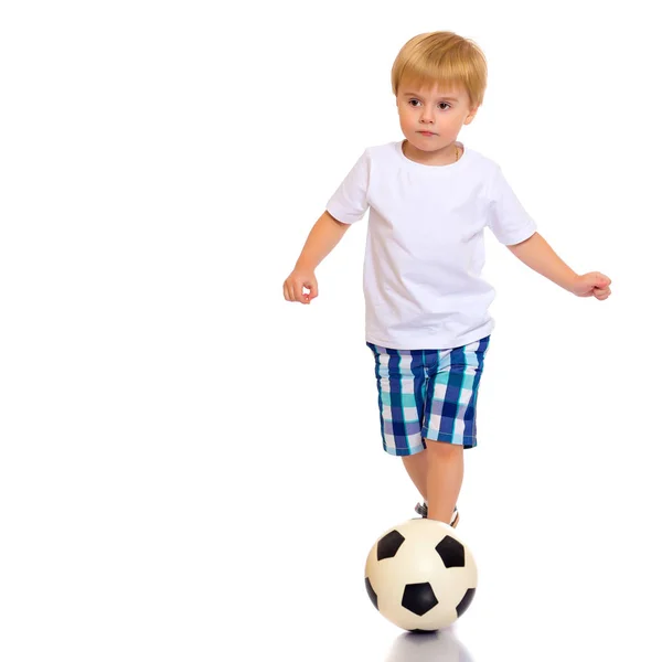 Pequeño niño está jugando con una pelota de fútbol . — Foto de Stock