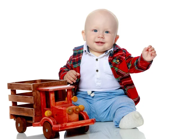 Een jongetje speelt met een speelgoedauto. — Stockfoto