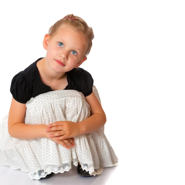 La niña está sentada en el suelo.. —  Fotos de Stock