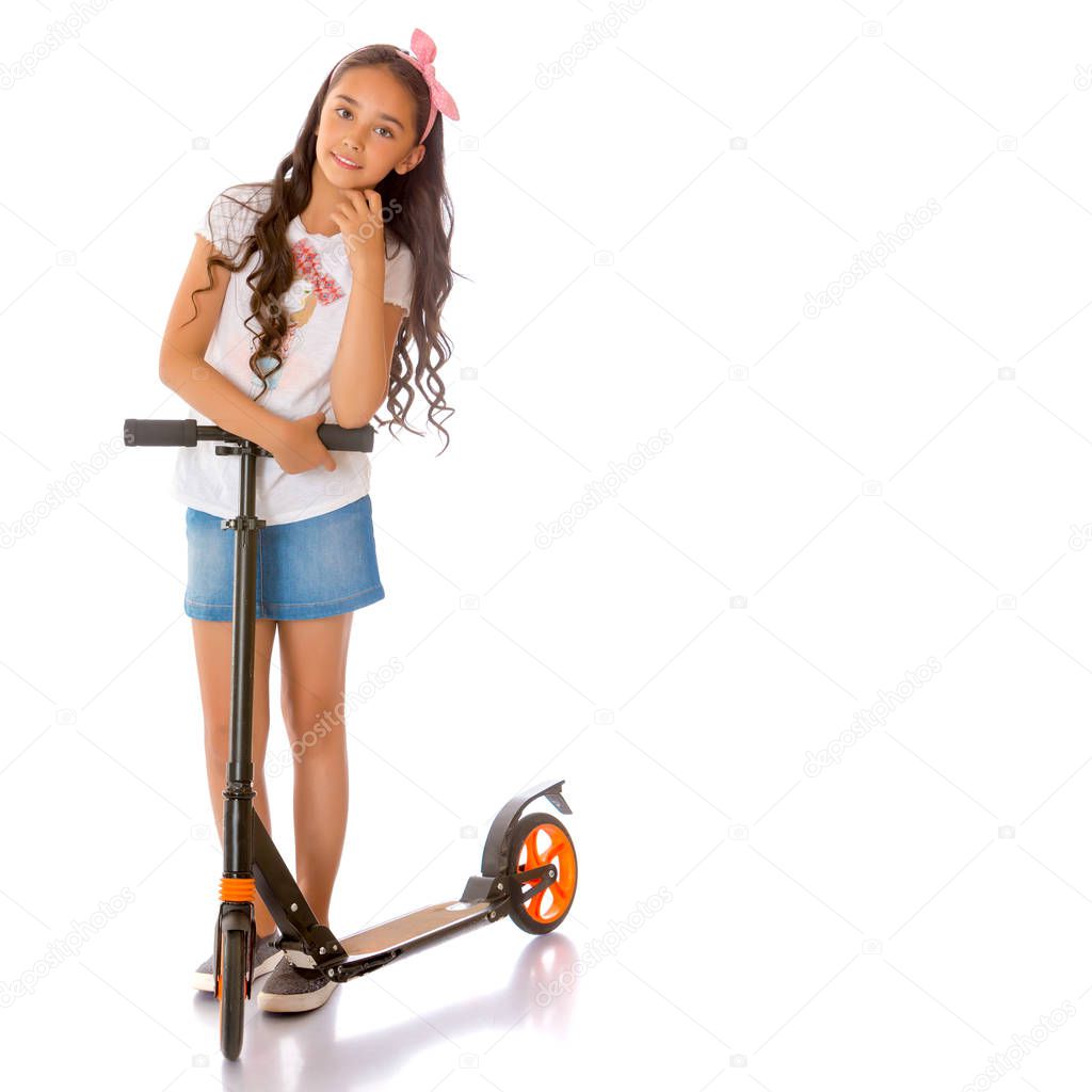 A teenage girl rides a scooter.