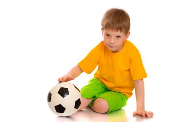 Küçük çocuk bir futbol topuyla oynuyor.