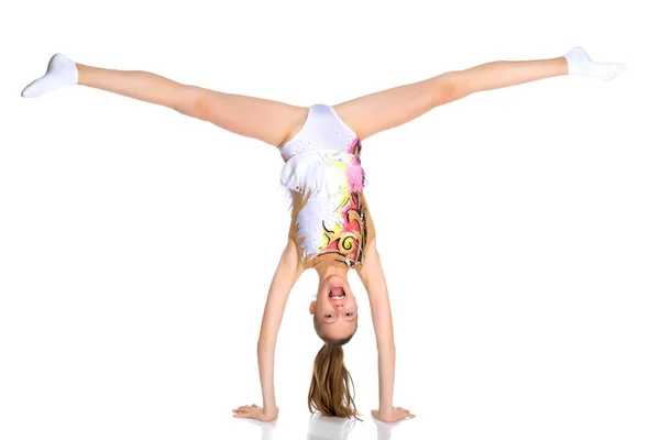 Die Turnerin macht einen Handstand mit angewinkelten Beinen. — Stockfoto