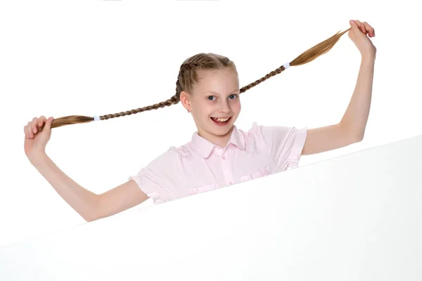 Het kleine meisje trekt zichzelf in pigtails. — Stockfoto