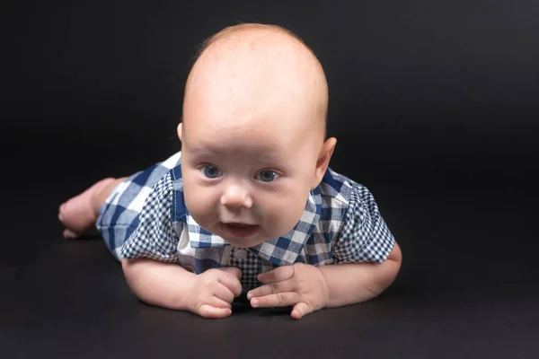 Een charmante baby kijkt naar de camera. — Stockfoto