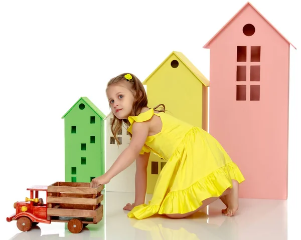 Menina está brincando com um carro de madeira . — Fotografia de Stock