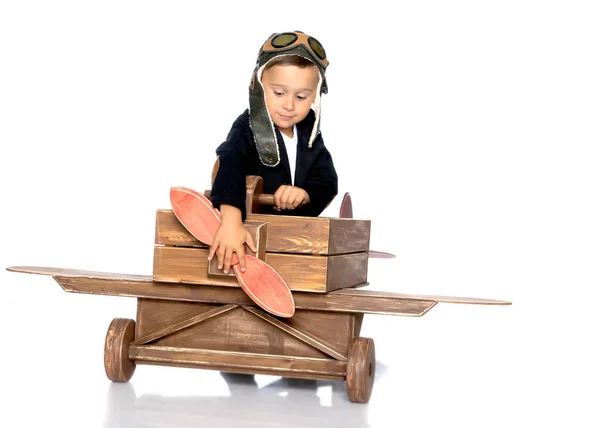 Jongetje met een houten vliegtuig. — Stockfoto