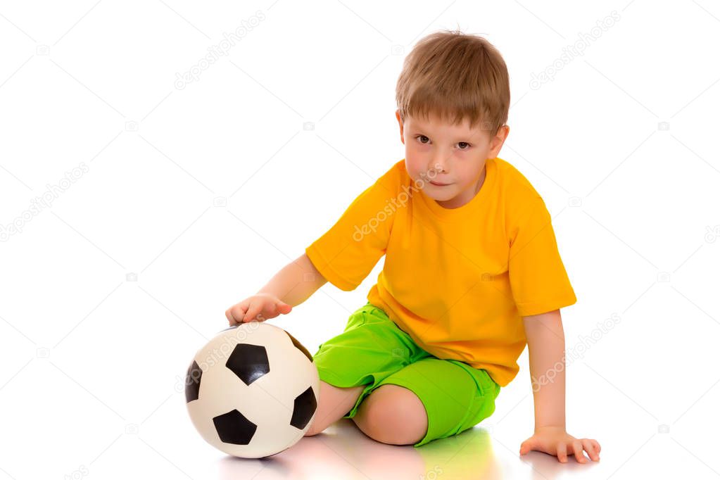 Little boy is playing with a soccer ball.