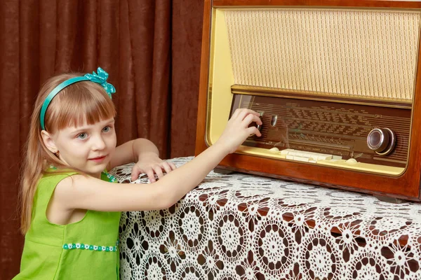 여자는 오래 된 라디오에 볼륨 노브를 설정합니다. 레트로 스타일. — 스톡 사진