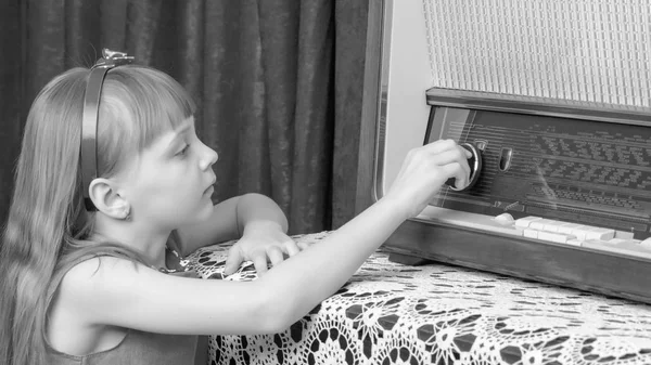 여자는 오래 된 라디오에 볼륨 노브를 설정합니다. 레트로 스타일. — 스톡 사진