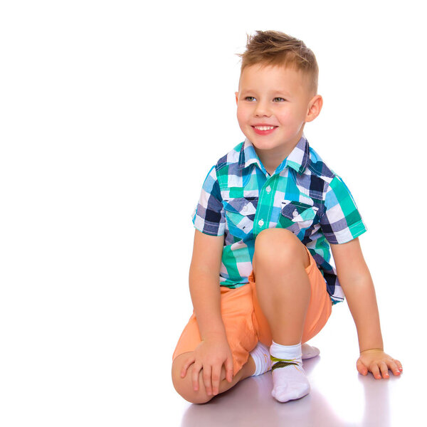 маленький мальчик сидит на полу
