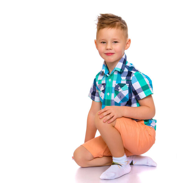 little boy is sitting on the floor