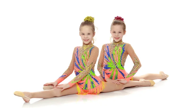 Two girls gymnast sitting on splits. — Stock Photo, Image