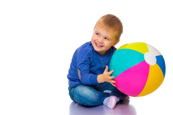 Um menino está brincando com uma bola . — Fotografia de Stock