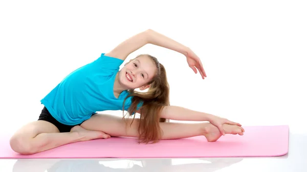 Malý gymnastka provést akrobatický prvek na podlaze. — Stock fotografie