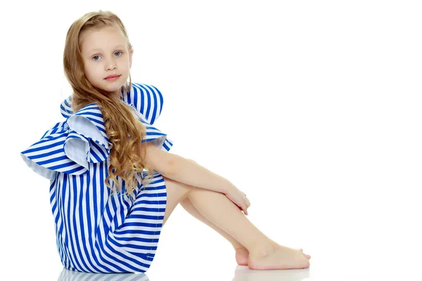 Entzückende kleine blonde Mädchen in sehr kurzen Sommer gestreiften Kleid. — Stockfoto