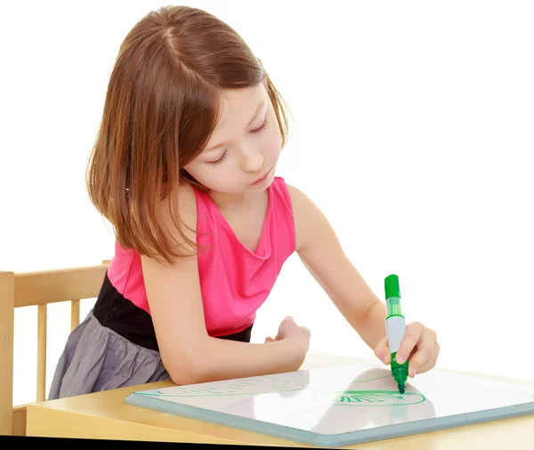 Petite fille dessine avec marqueur assis à la table . — Photo