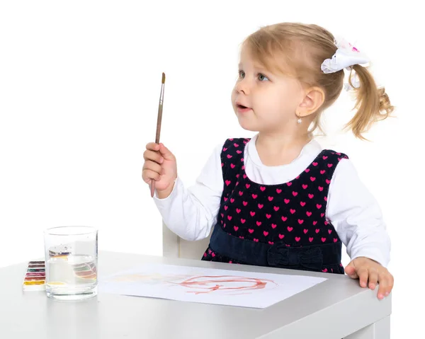 En liten flicka är teckning vid bordet. — Stockfoto