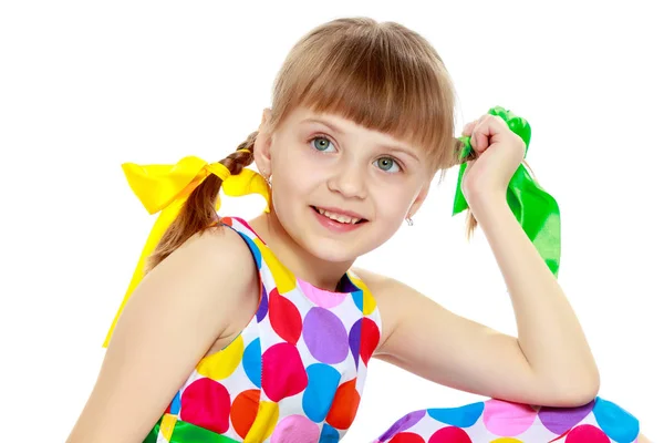 Una niña en un vestido con un patrón de circl multicolor — Foto de Stock