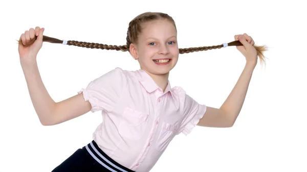 The little girl is pulling herself in pigtails. — Stock Photo, Image