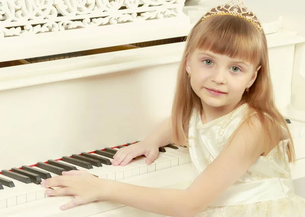 A girl is posing near a white grand piano. — Stock Photo, Image