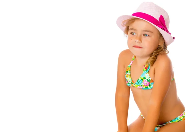 Una pequeña chica bronceada en traje de baño y sombrero . — Foto de Stock