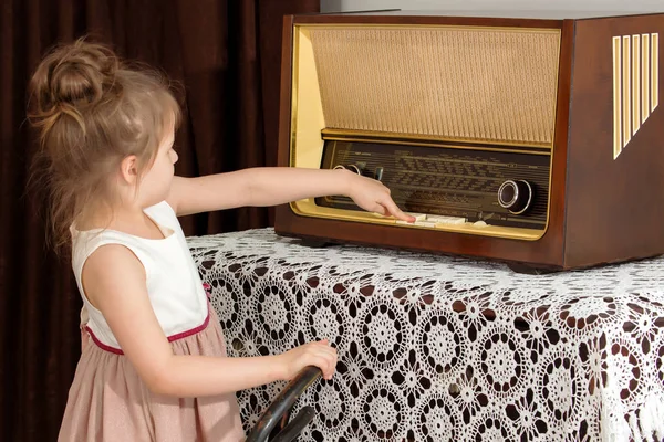 Niña escucha la vieja radio . —  Fotos de Stock