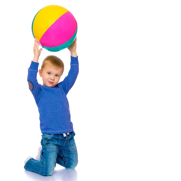 Um menino está brincando com uma bola . — Fotografia de Stock