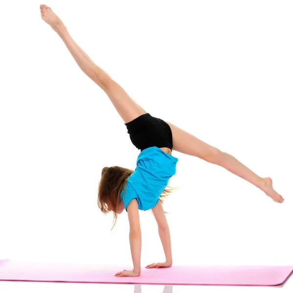 Girl gymnast performs a handstand. — Stock Photo, Image