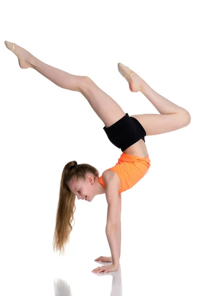 Die Turnerin macht einen Handstand mit angewinkelten Beinen. — Stockfoto