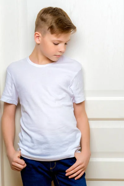 Modny chłopczyk w pobliżu białe drzwi. — Zdjęcie stockowe